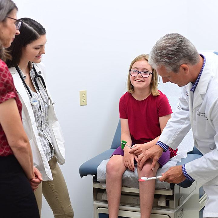 Physician Assistant providing care for a youth in a medical office.